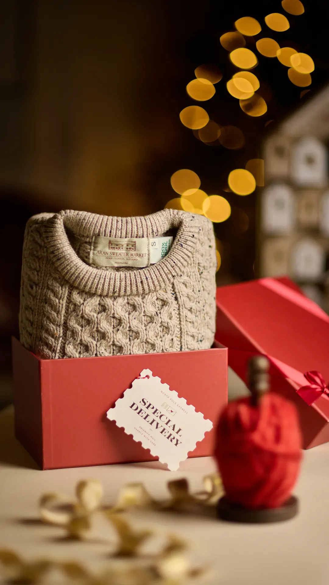 Aran knit jumper box and wrapping for Christmas with a christmas tree in the background