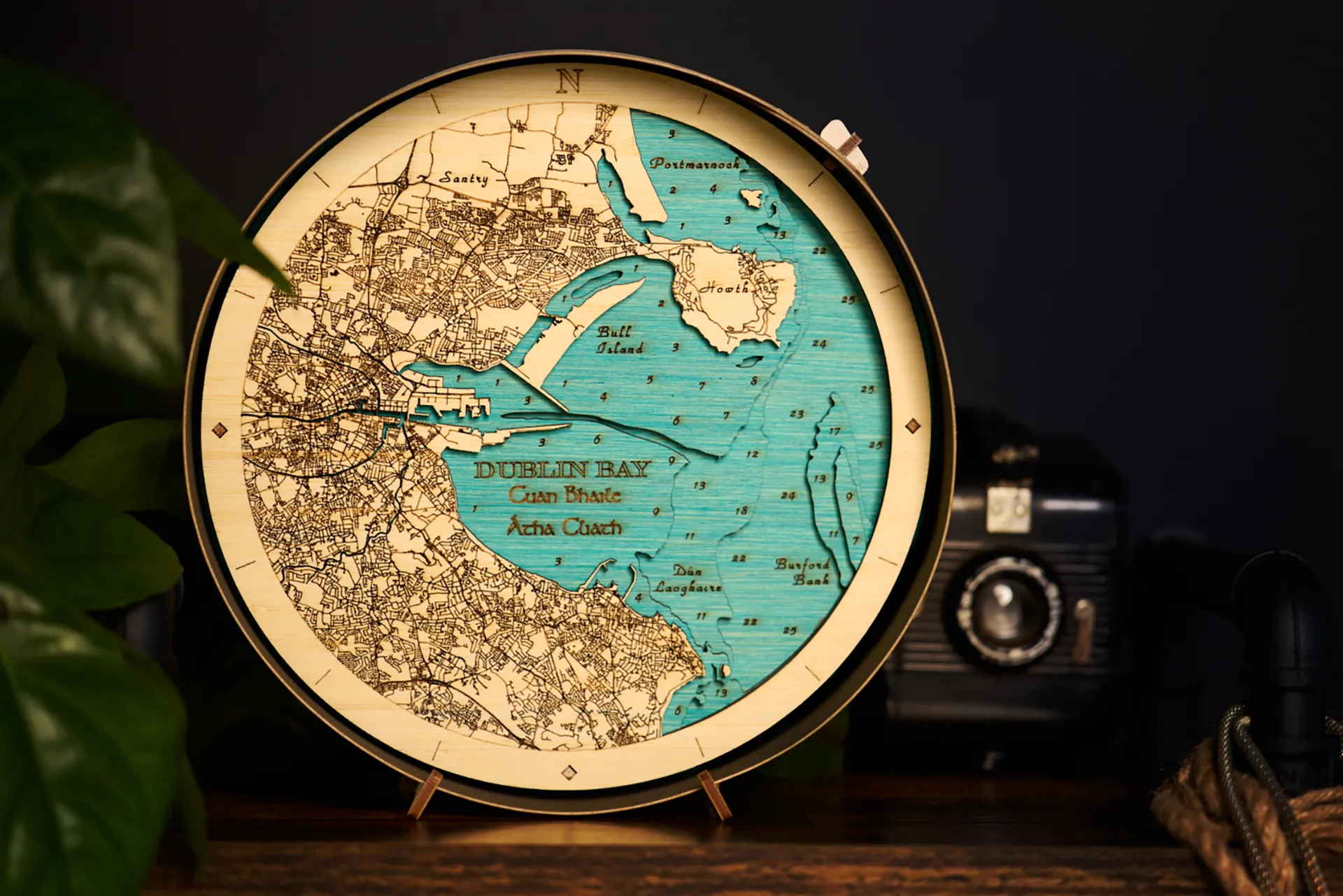 A decorative map art piece by Outcrop sits on a display shelf in a luxury home